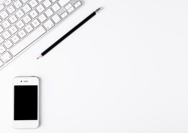 Siyah kalem ve telefon üstünde okul sırası ile beyaz klavye