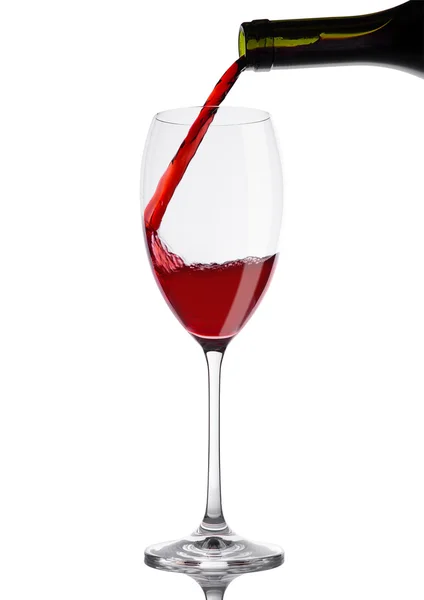 Выливание красного вина из бутылки в бокал на белом — стоковое фото