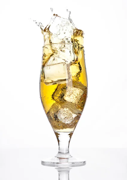 Copo de cidra de cerveja com respingo de cubo de gelo no branco — Fotografia de Stock