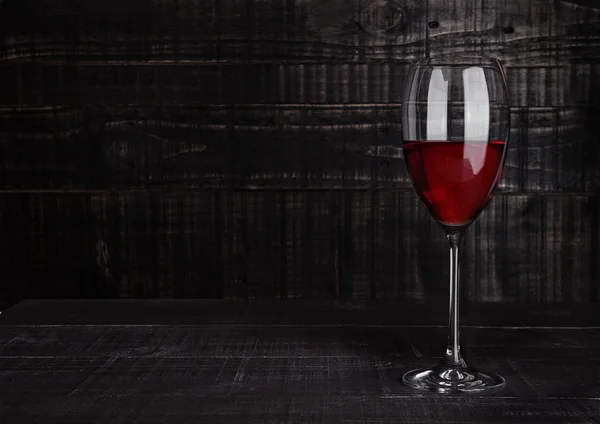 Copa de vino tinto con reflejos sobre tabla de madera — Foto de Stock