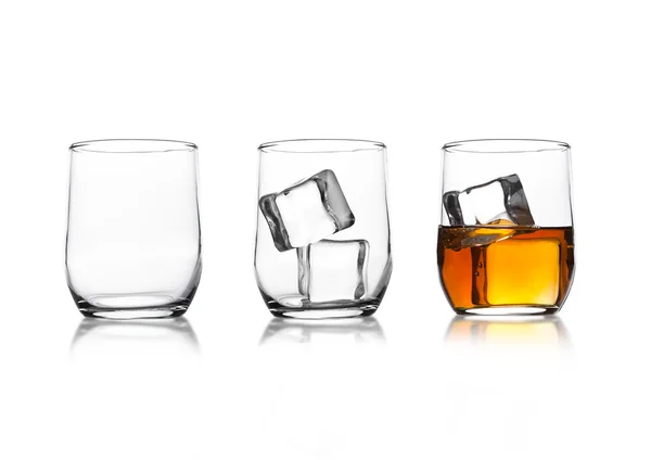 Gläser mit Whiskey und Eiswürfeln und leerem Glas — Stockfoto