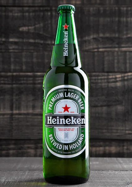 LONDRES, UK-OCTUBRE 17, 2016: Botella de cerveza Heineken Lager sobre fondo grunge de madera. Heineken es el producto estrella de Heineken International —  Fotos de Stock