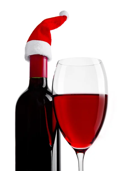 Bottle and glass of red wine with santa hat — Stock Photo, Image