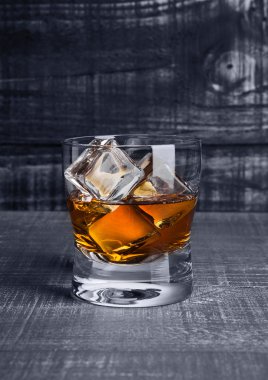 Viski mavi ahşap üzerine buz küpleri ile Glasss