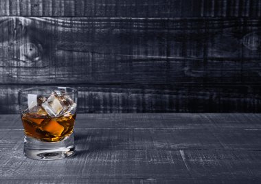 Viski mavi ahşap üzerine buz küpleri ile Glasss