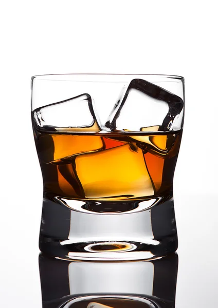 Glasss of whiskey with ice cubes with reflection — ストック写真