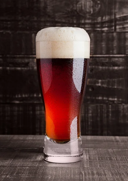 Sticlă de bere maro cu spumă pe lemn — Fotografie, imagine de stoc