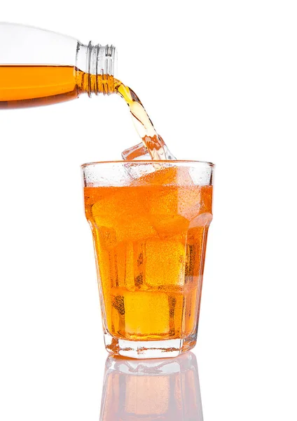 Pouring orange energy soda drink in glass with ice — Stock Photo, Image