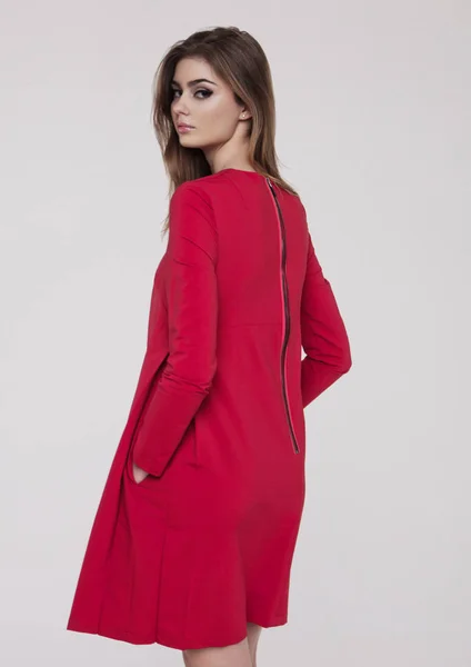 Hermosa joven en vestido rojo de moda en gris — Foto de Stock