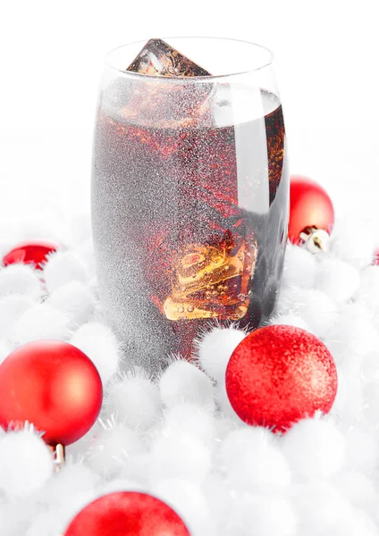 Glass of cola soda  on snow and christmas balls — Stock Photo, Image