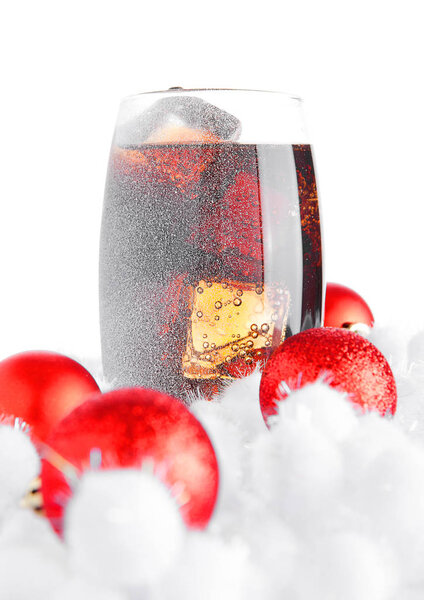 Glass of cola soda  on snow and christmas balls