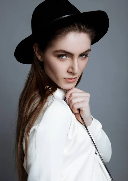Hermosa modelo de moda en blanco con sombrero negro —  Fotos de Stock