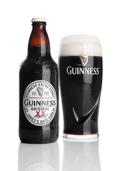 London, Storbritannien - 29 November 2016: Guinness extra stout öl flaska och glas på vit bakgrund. Guinness öl har producerats sedan 1759 i Dublin, Irland. — Stockfoto