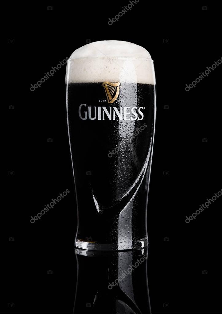 LONDON, UK - NOVEMBER 29, 2016: Glass of Guinness original beer on black background. Guinness beer has been produced since 1759 in Dublin, Ireland.