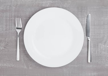 Çatal ve bıçak ahşap üzerine beyaz yuvarlak tabak