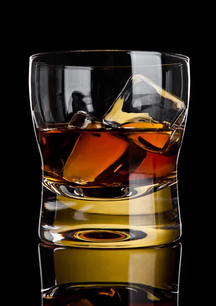 Sklenici whisky s golden ice cubes reflexe — Stock fotografie