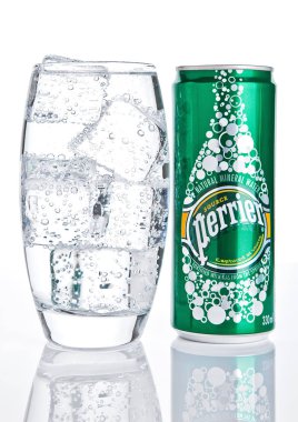 Londra, İngiltere - 06 Aralık 2016: Cam buz ve teneke Perrier köpüklü su ile. Perrier doğal şişe maden suyu dünya çapında satılan Fransız bir markasıdır..