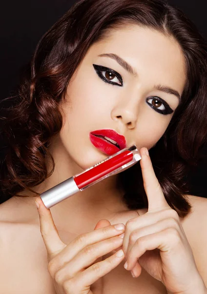 Hermosa chica modelo sosteniendo lápiz labial rojo líquido — Foto de Stock