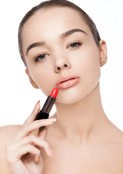 Menina modelo bonita segurando maquiagem tubo de batom — Fotografia de Stock