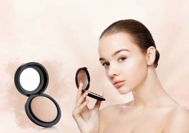 Beauty makeup model holding powder foundation