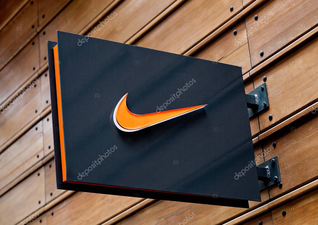 LONDON, UK - JUNE 02, 2017: Nike logo on black display plate on wooden background. Nike, Inc. is an American corporation  manufacturing of footwear, apparel, equipment, accessories and services
