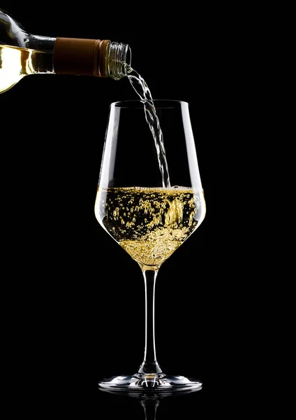 Odlewania białego wina z butelki do szkła na czarny — Zdjęcie stockowe