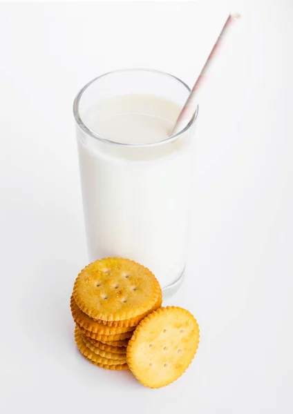 Bicchiere di latte con cracker di formaggio rotondi su bianco — Foto Stock