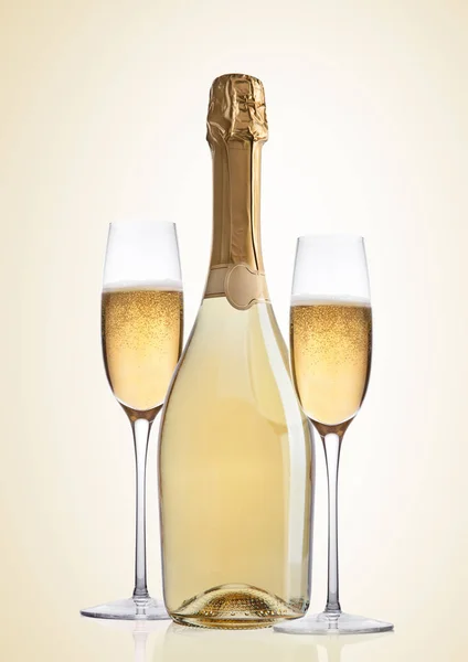 Bottle and glasses of yellow champagne on yellow — Stock Photo, Image