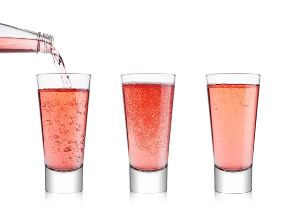 Pouring pink soda lemonade from bottle to glass — Stock Photo, Image