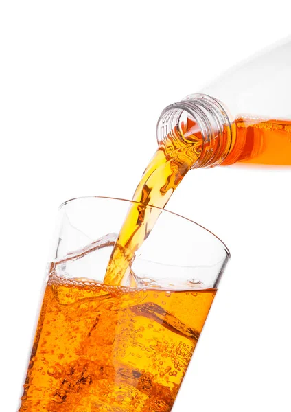 Наливання апельсинового енергетичного напою з пляшки до скла — стокове фото