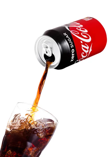 LONDON, UK - JANUARY 02, 2018: Pouring Coca Cola Zero soda drink from aluminium tin to glass on white. The drink is produced and manufactured by The Coca-Cola Company. — Stock Photo, Image