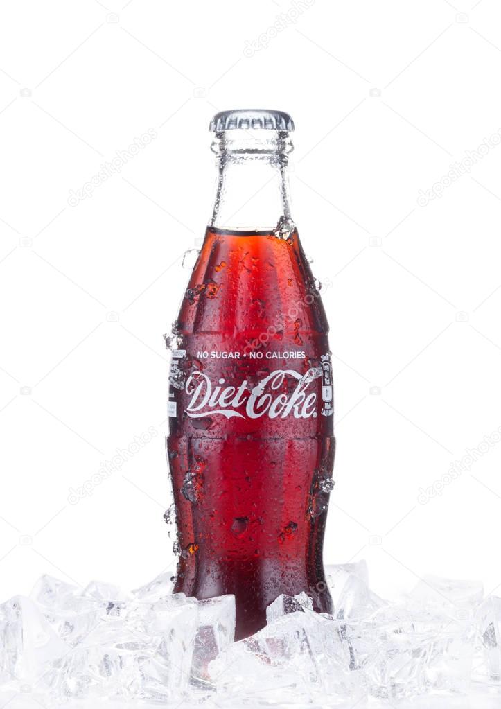 LONDON, UK - JANUARY 02, 2018: Cold glass bottle of Diet Coca Cola drink  with ice and dew on white background. The drink is produced and manufactured by The Coca-Cola Company.
