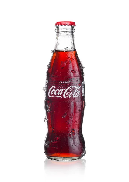 LONDON, UK - JANUARY 02, 2018: Cold glass bottle of Coca Cola drink  with ice and dew on white. The drink is produced and manufactured by The Coca-Cola Company. — Stock Photo, Image