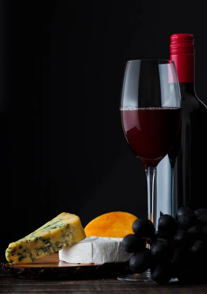 Flasche und Glas Rotwein mit Käseauswahl — Stockfoto