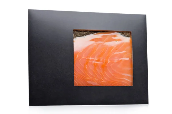 Пакет из черной бумаги со свежими ломтиками лосося — стоковое фото