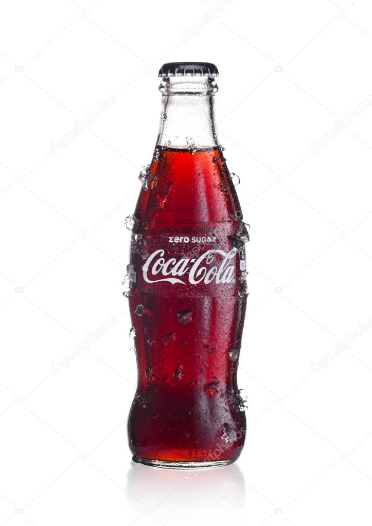 LONDON, UK - JANUARY 02, 2018: Cold glass bottle of Zero Coca Cola drink with ice and dew on white background. The drink is produced and manufactured by The Coca-Cola Company.