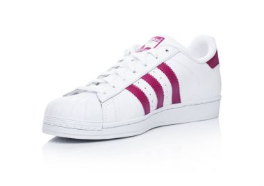 Londra, İngiltere - 12 Ocak 2018: Adidas Originals Superstar kırmızı beyaz ayakkabılarla. Tasarımları ve spor ayakkabı, giyim ve aksesuarları üreten Alman çok uluslu şirket.
