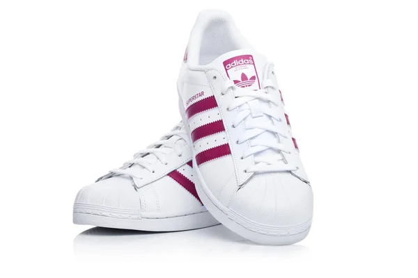 LONDRA, UK - 12 GENNAIO 2018: Adidas Originals Superstar scarpe rosse sul bianco.Società multinazionale tedesca che progetta e produce scarpe sportive, abbigliamento e accessori . — Foto Stock