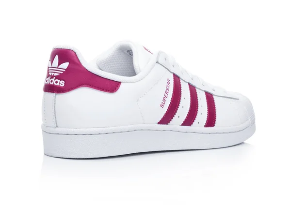 LONDRA, UK - 12 GENNAIO 2018: Adidas Originals Superstar scarpe rosse sul bianco.Società multinazionale tedesca che progetta e produce scarpe sportive, abbigliamento e accessori . — Foto Stock