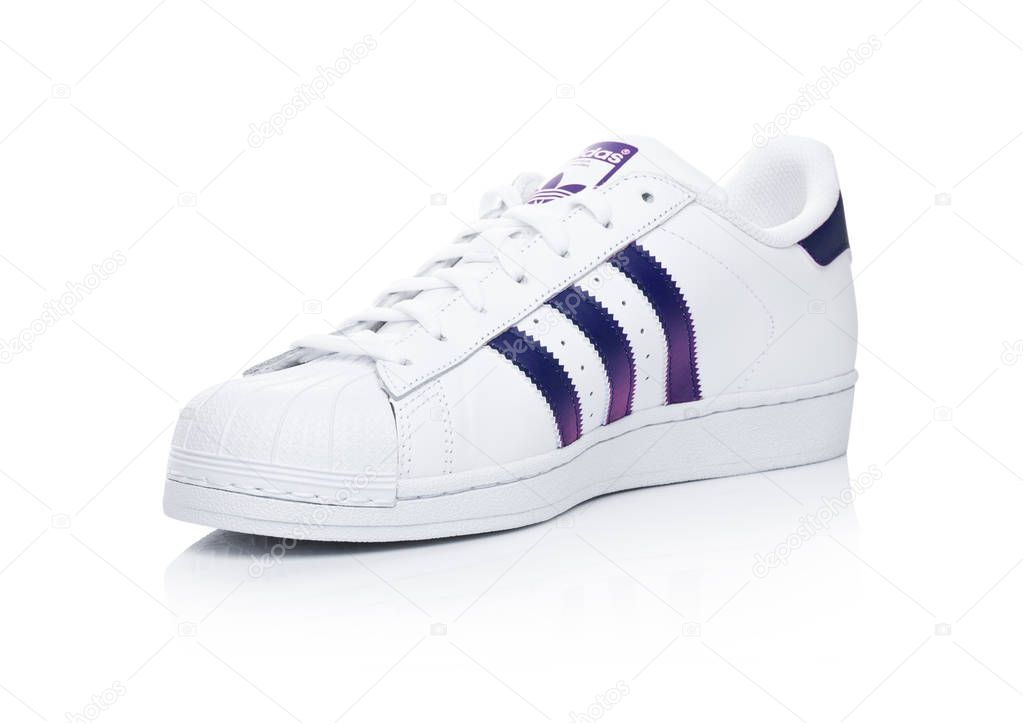 LONDON, UK - JANUARY 24, 2018: Adidas Originals Superstar blue shoes on white background.German multinational corporation that designs and manufactures sports shoes, clothing and accessories.