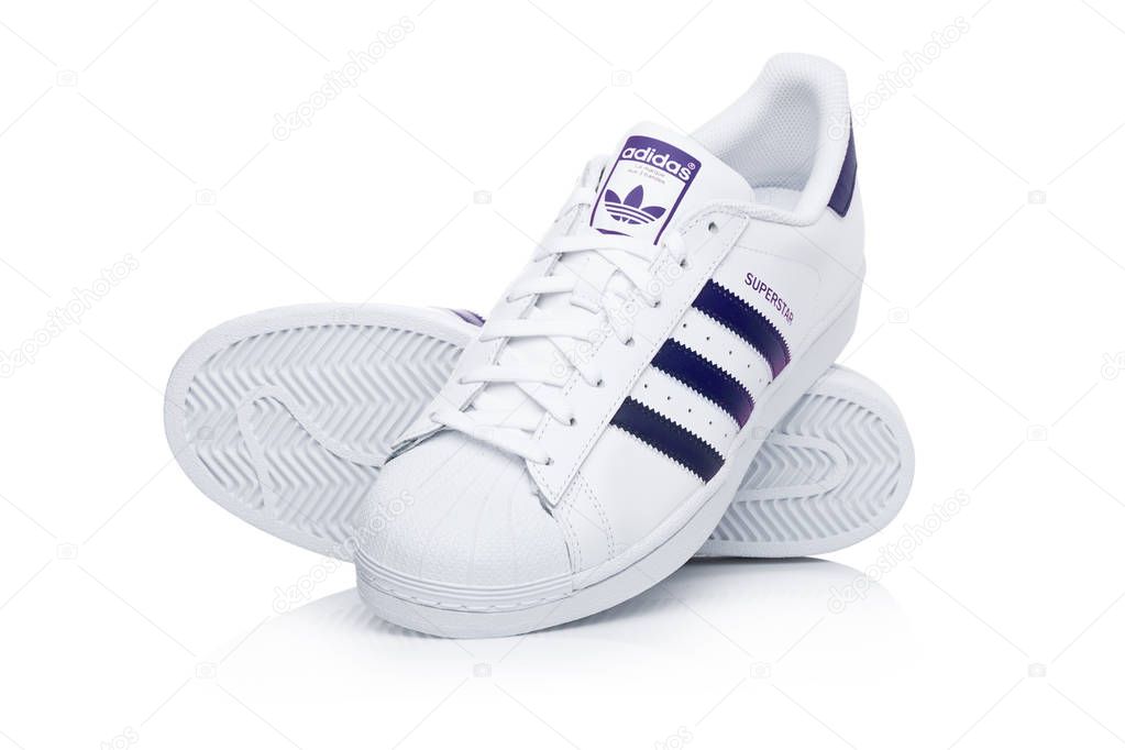 LONDON, UK - JANUARY 24, 2018: Adidas Originals Superstar blue shoes on white background.German multinational corporation that designs and manufactures sports shoes, clothing and accessories.