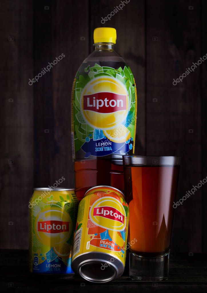 LONDON, UK - JANUARY 24, 2018: Plastic bottle and aluminium can with glass  of Lipton green ice tea on wooden background