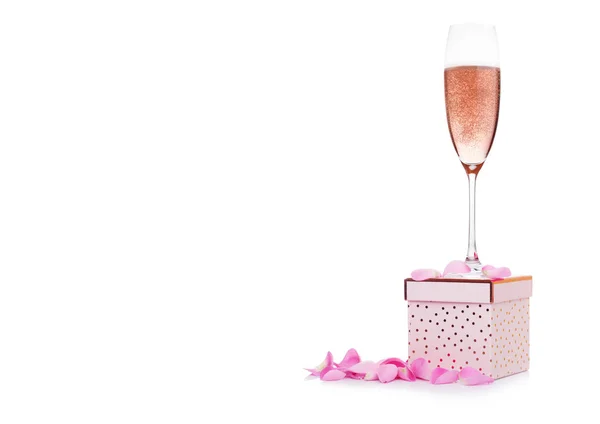 Glas roze champagne op de top van roze geschenkdoos — Stockfoto