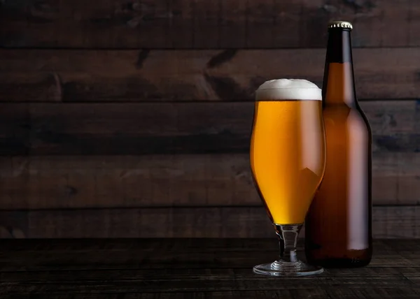 Glass and bottle of golden lager beer with foam — Stock Photo, Image