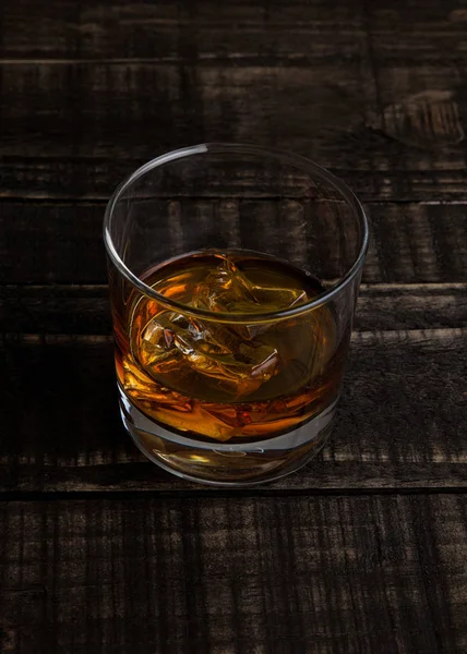 Verre de whisky avec glaçons sur table en bois — Photo