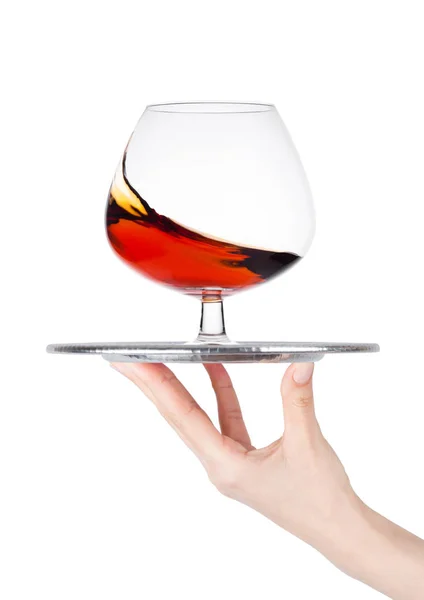 Hand holds tray with glass of brandy cognac — Stock Photo, Image