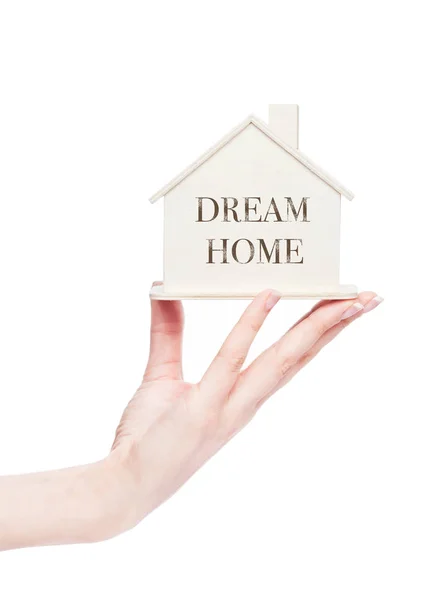 Ženská ruka drží dřevěný dům model s textem — Stock fotografie