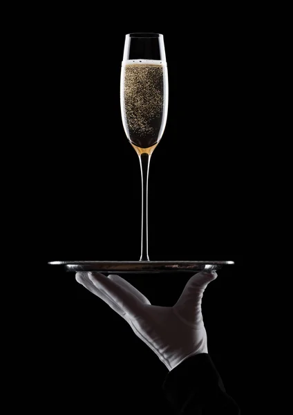 Ręka z rękawicy posiada zasobnik z kieliszka do szampana — Zdjęcie stockowe