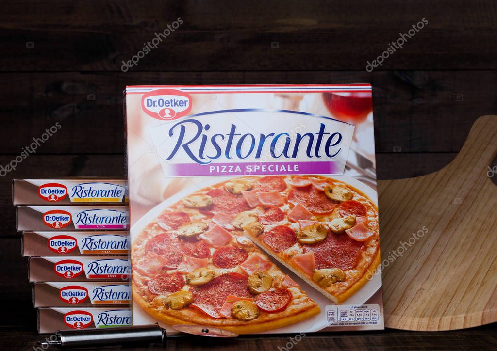 LONDON, UK - MARCH 01, 2018: Boxes of Dr.Oetker Pizza Pepperoni-Salame on wooden background with board and cutting knife.