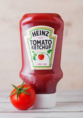 Londra, İngiltere - 10 Mart 2018: Plastik şişe Heinz ketçap çiğ domates ile ahşap üzerine. H.J. Heinz şirketi tarafından üretilen